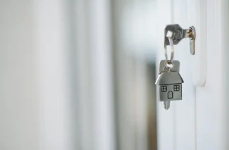 ключ с брелоком в виде домика в замке входной двери